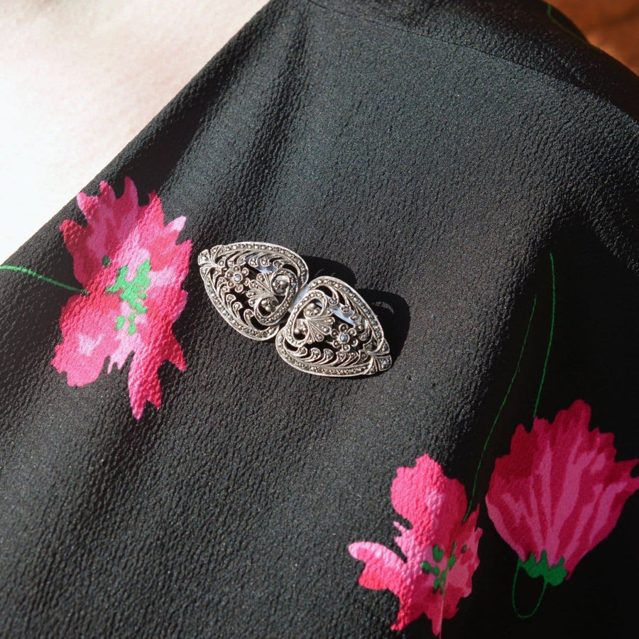 Art-Deco-Brosche aus Silber und Markasit mit doppeltem Clip auf einer schwarzen Blumenplatte, die die Eleganz der 1920er Jahre widerspiegelt.