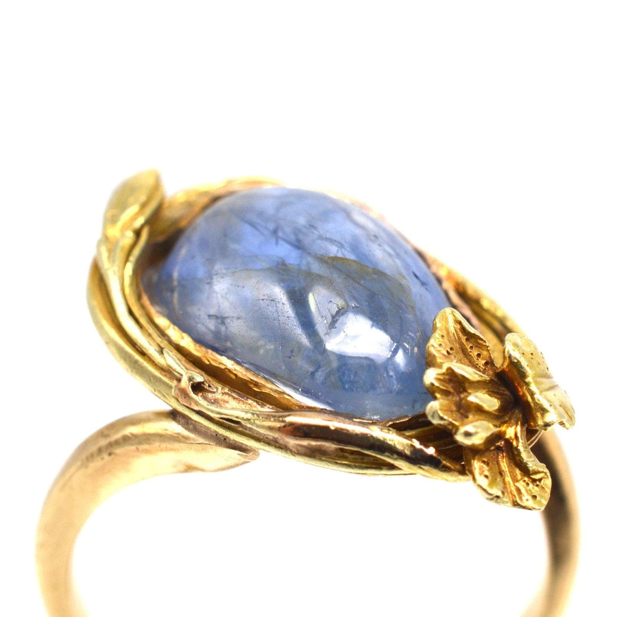 Jugendstil-Ring aus 18-karätigem Gold mit einem großen Kyanit-Cabochon und einem Blumenmuster, das die Farben Blau und Gold zur Geltung bringt.