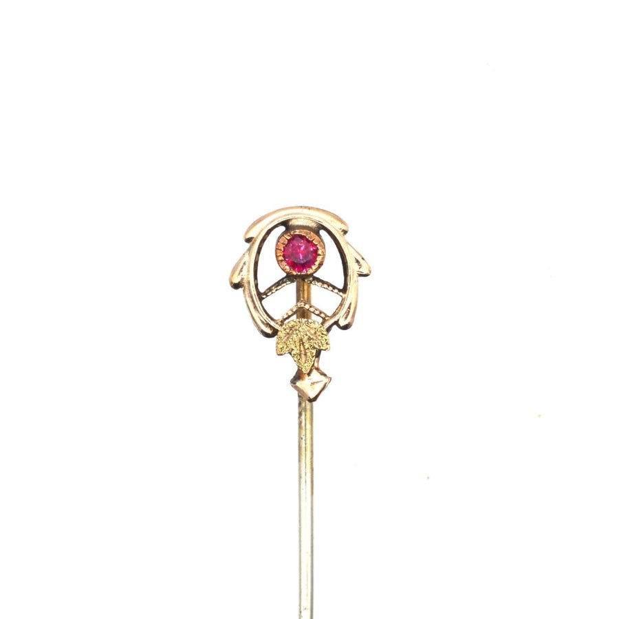 Jugendstil-Krawattennadel aus zweifarbigem Gold mit Rubin, mit stilisierten Blättern und Millegrain-Fassung für stilvolle Eleganz.