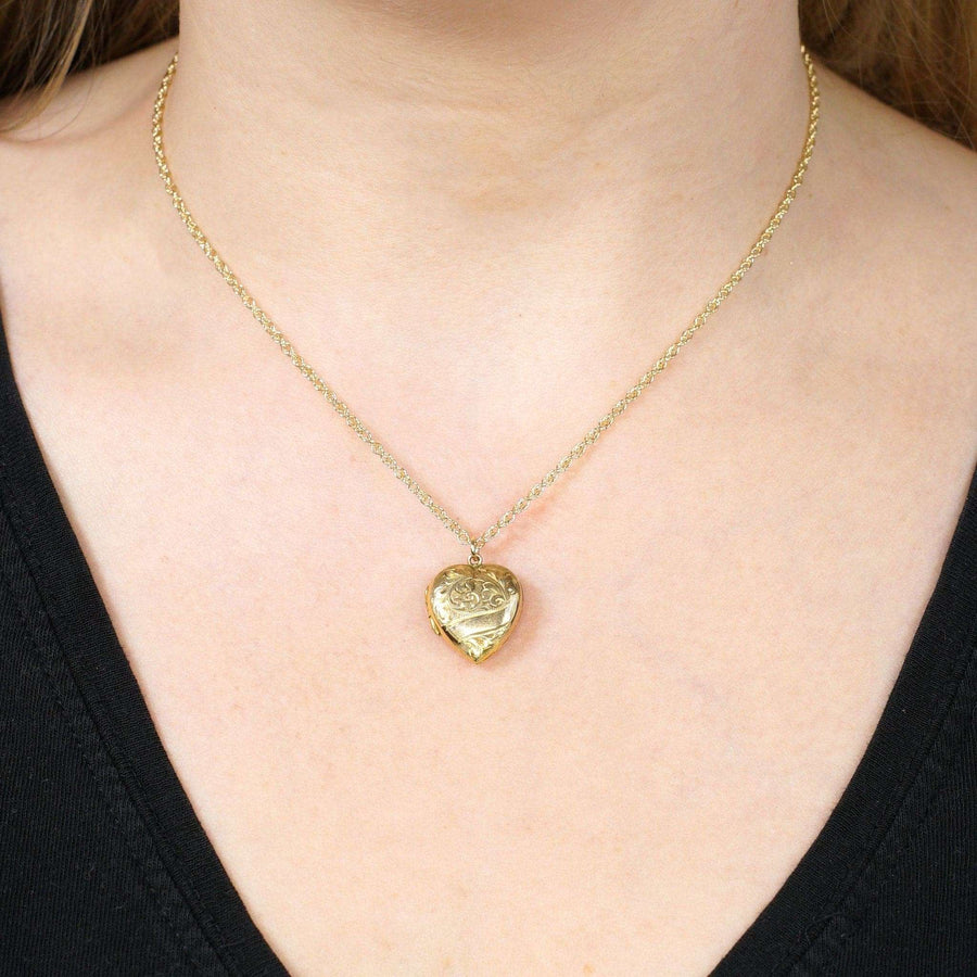9ct yellow gold heart pendant necklace worn on a woman's neck, featuring an intricate design and delicate chain.
