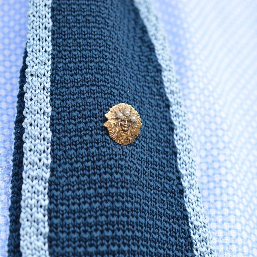 Indianerhäuptlingsnadel aus 15 Karat Gold mit Perlen auf einer blauen Strickkrawatte, perfektes Accessoire für ein knackiges Revers.