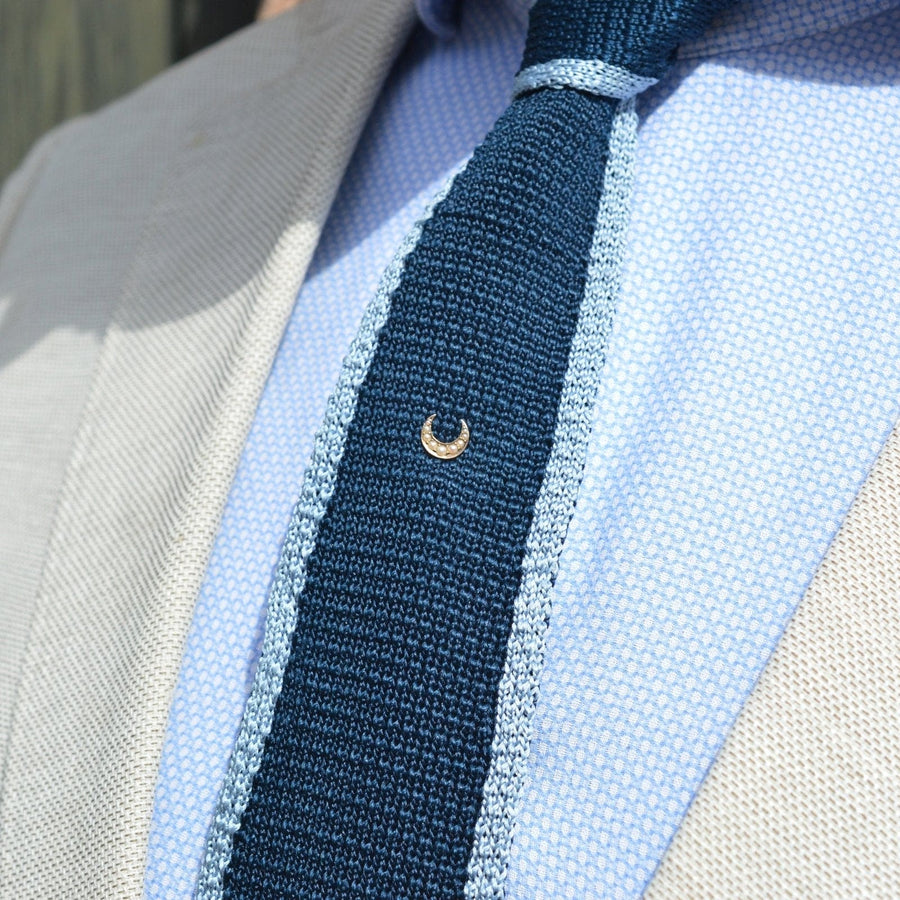 Edwardian 15ct gold Cheshire moon Krawattennadel mit geteilten Perlen auf einer blauen Krawatte in einem stilvollen Ensemble.
