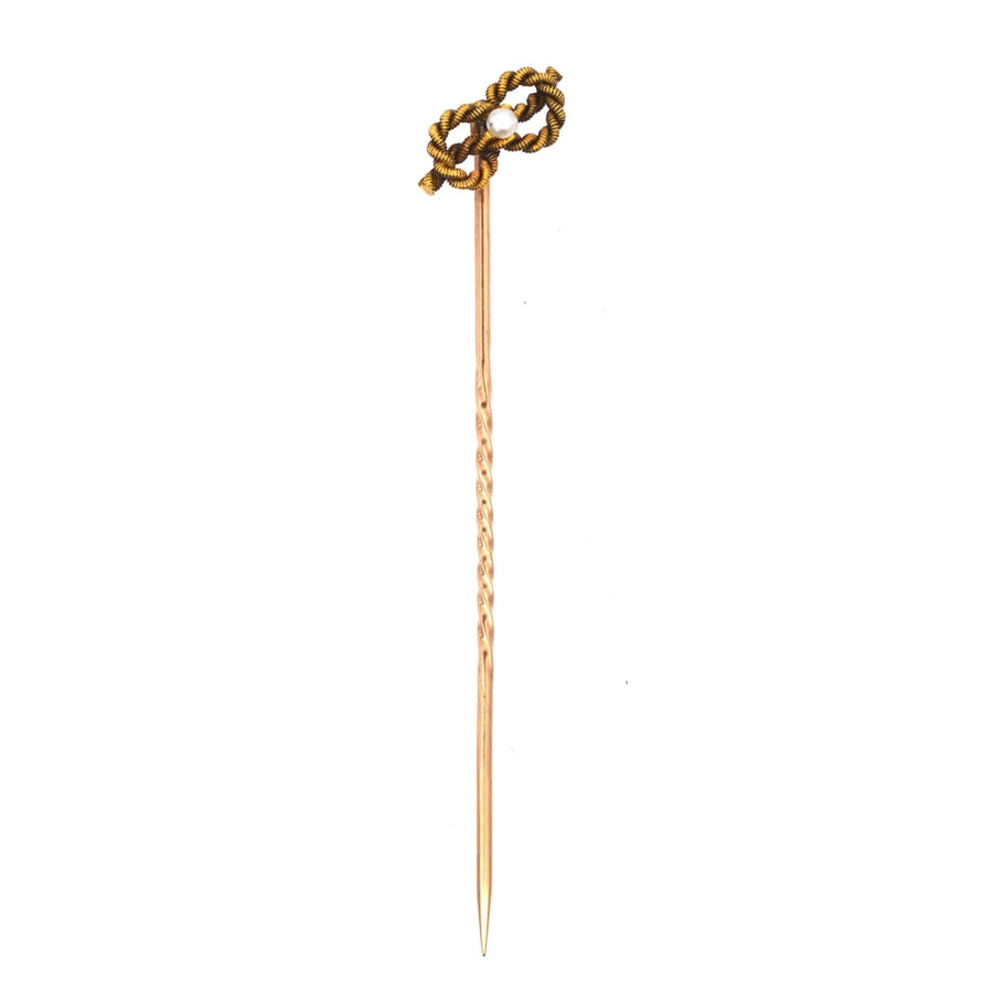 Edwardian 15ct gold tie pin featuring a lover's knot and natural pearl, symbolizing infinite love.