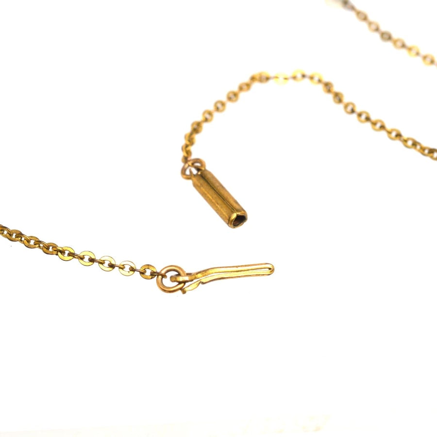 Nahaufnahme einer goldenen Halskette mit einem Verschluss, der feine Handwerkskunst und Eleganz ausstrahlt.