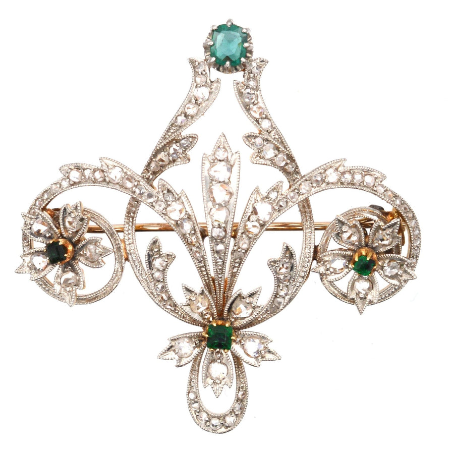 Edwardian 15ct gold and platinum brooch with emerald and rose diamonds, featuring intricate floral design.