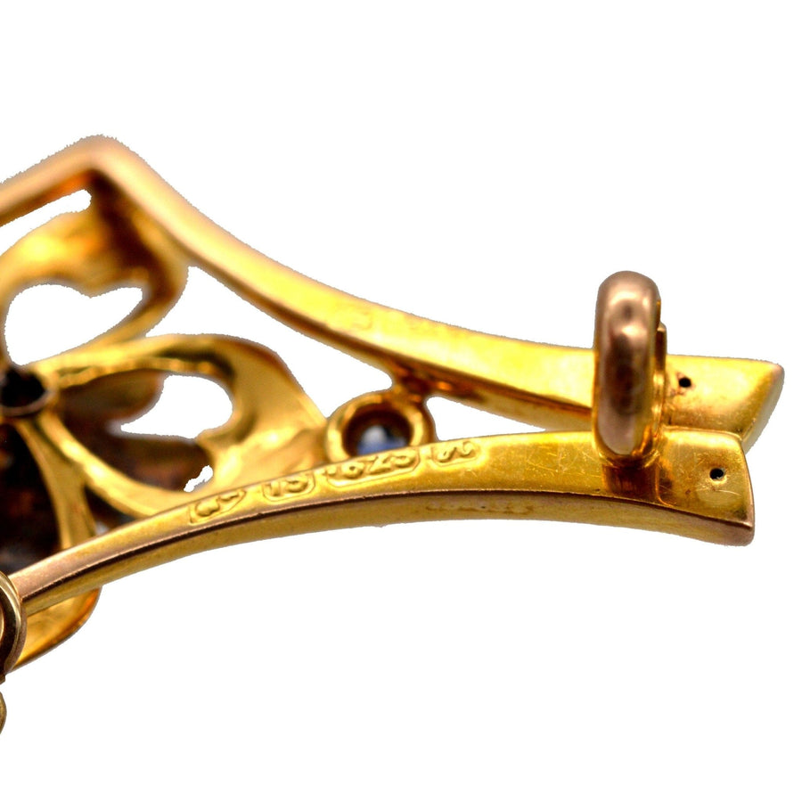 Nahaufnahme der Rückseite einer edwardianischen Blumenbrosche aus 15 Karat Gold mit kompliziertem Design und Punzierungsdetails.