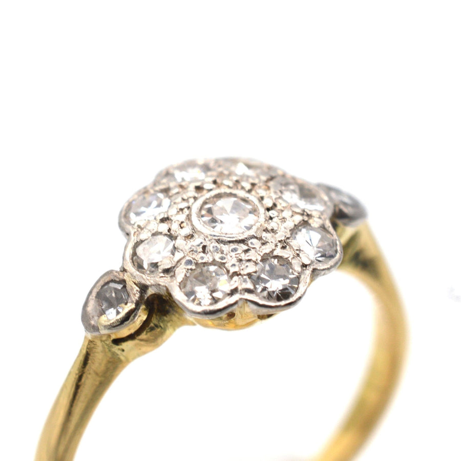 Edwardian 18ct gold diamond cluster ring with floral design and side diamonds, perfect for engagement.