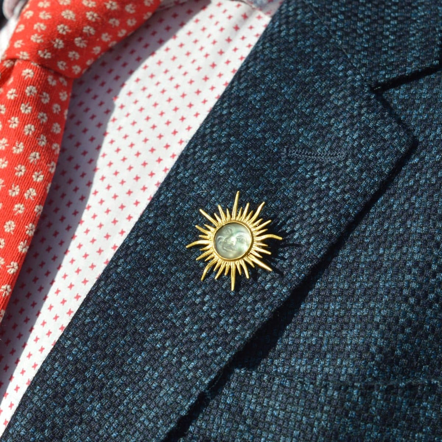 Edwardianische Sonnenschliff-Brosche aus 18 Karat Gold mit opalisierendem Glas, die am Revers getragen wird und Vintage-Eleganz ausstrahlt.