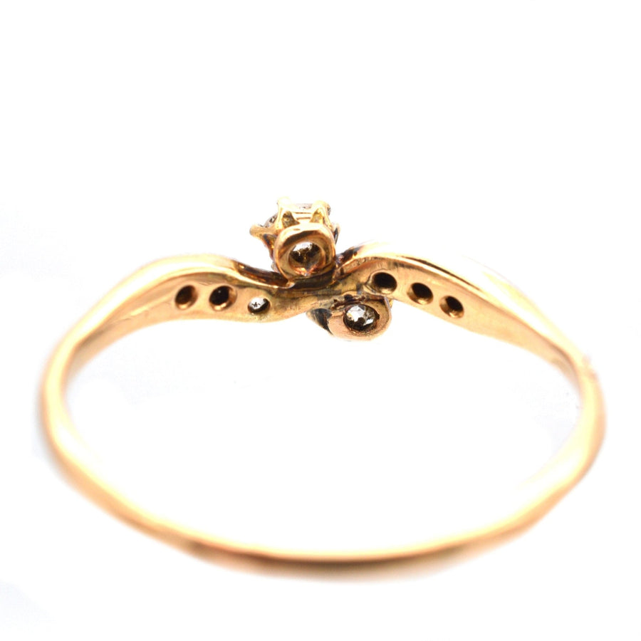 Edwardianischer Gold- und Platinring mit zwei gekreuzten Steinen und Diamantschultern, perfekt für romantische Anlässe.