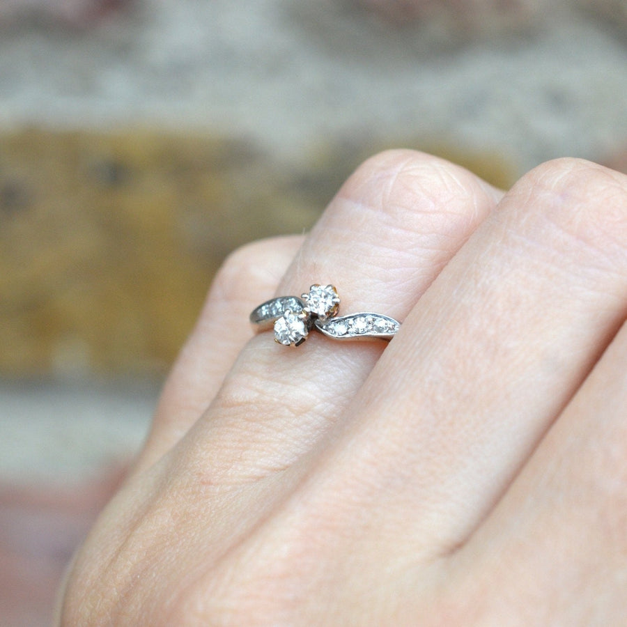 Edwardianischer Zwei-Stein-Diamant-Crossover-Ring aus 18 Karat Gold und Platin, an einer Hand getragen.