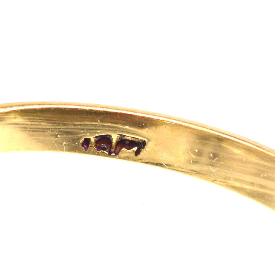 Nahaufnahme der Punzierung eines edwardianischen Rings aus 18 Karat Gold, der feine Handwerkskunst und Details zeigt.
