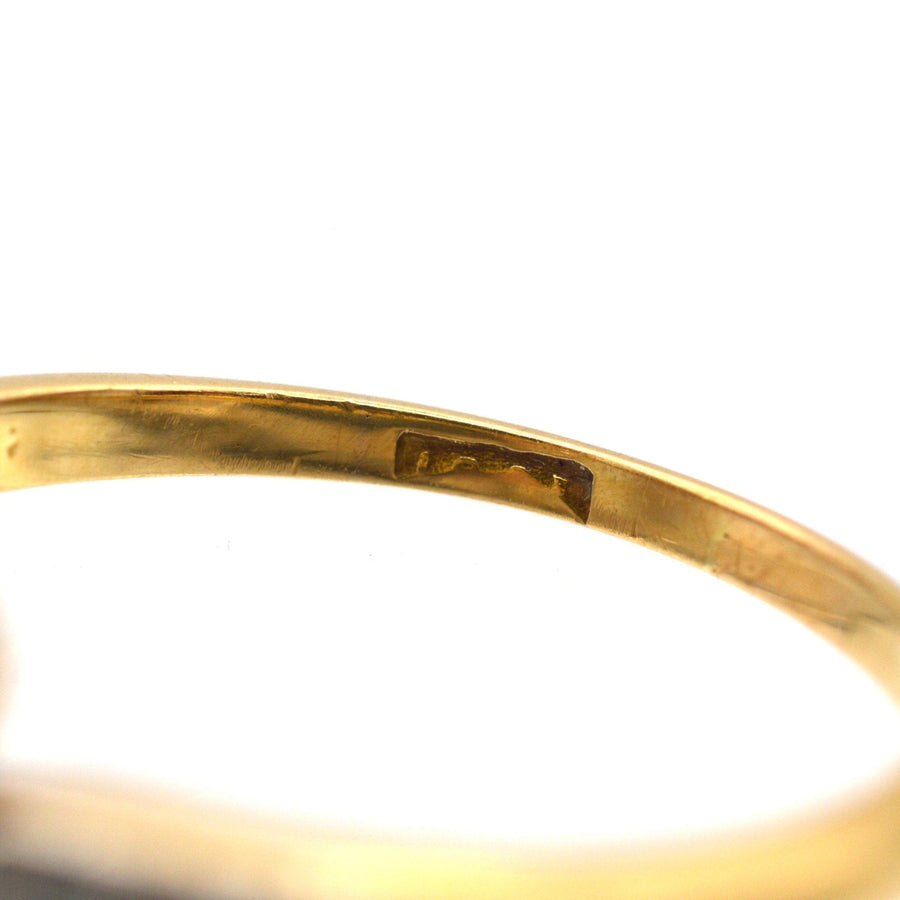 Nahaufnahme des Innenrings mit der Punzierung eines edwardianischen Crossover-Rings aus Gold und Platin.