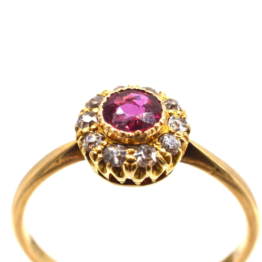 Edwardianischer Ring aus 18 Karat Gold mit einem Rubin in der Mitte, der von zehn funkelnden Diamanten umgeben ist. Ideal für Verlobungen oder Jahrestage.