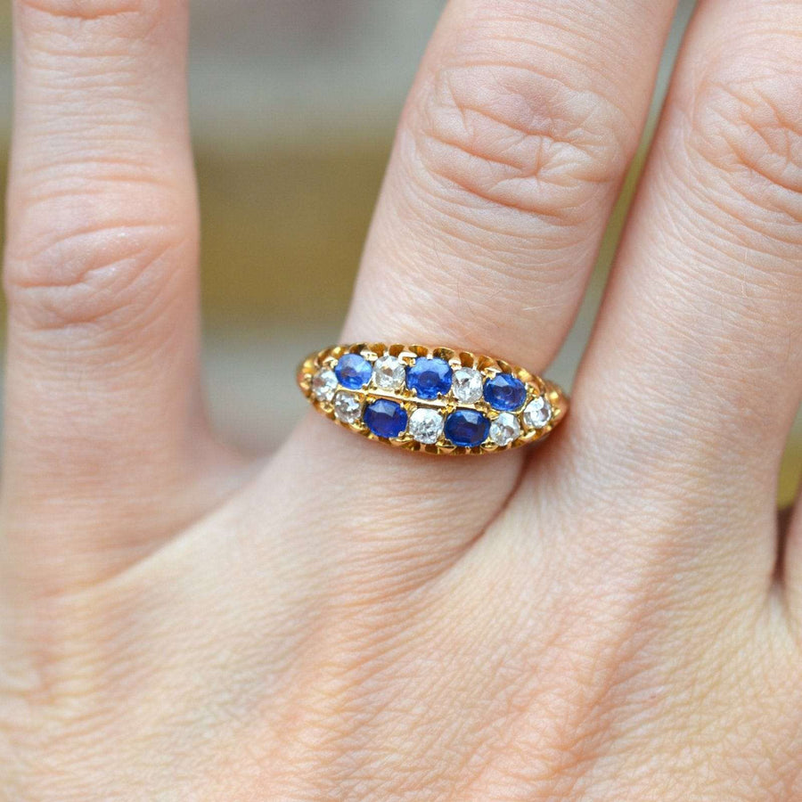 Edwardianischer Ring aus 18-karätigem Gold mit Saphiren und Diamanten im Minenschliff, gefasst auf einer Hand.