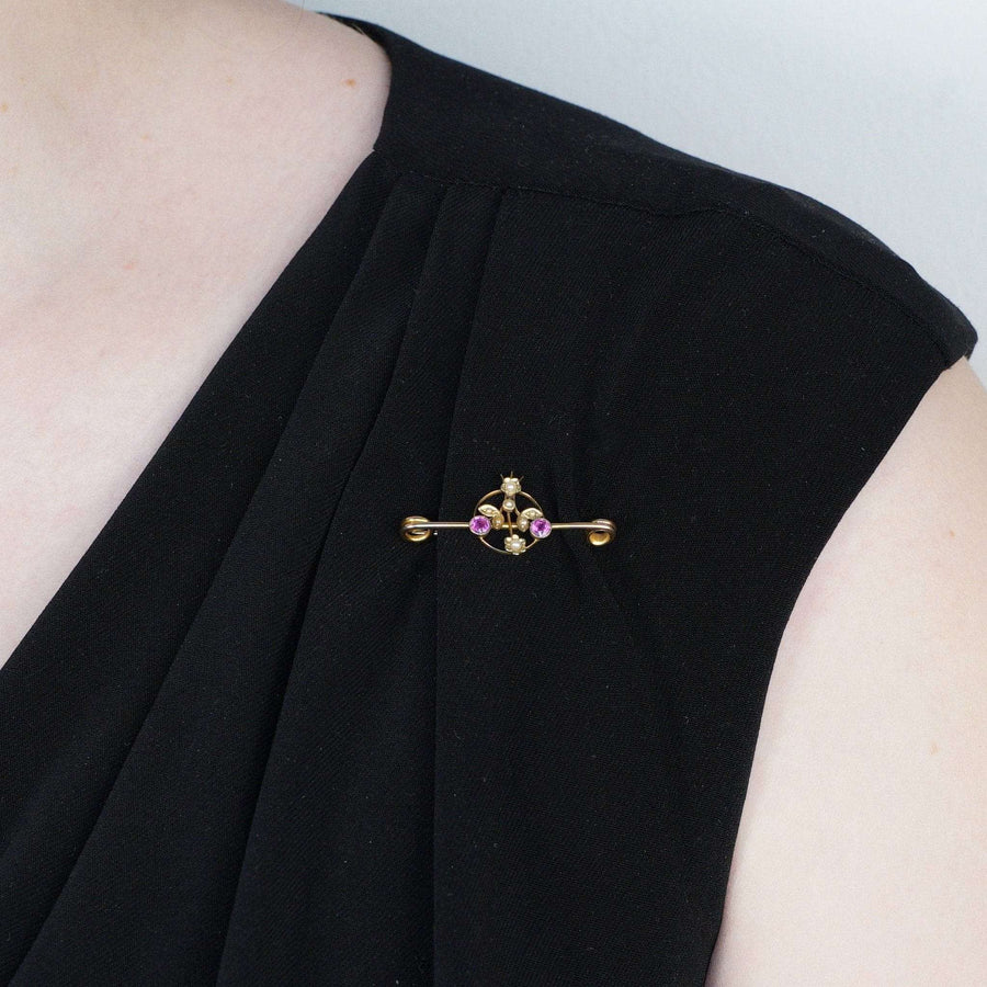 Edwardian 9ct Gold Brosche mit rosa Saphir und Perle Blumen, elegant auf einem schwarzen Kleid angezeigt.