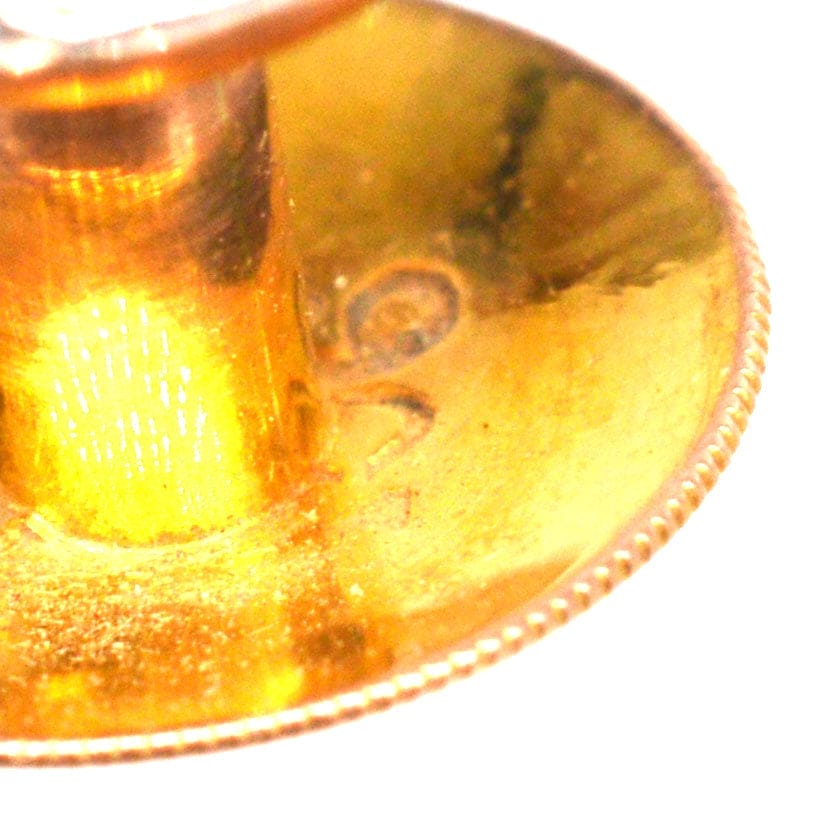 Nahaufnahme des Punzierungszeichens und Detailansicht eines Kleidungssteckers aus 9 Karat Gold, der Handwerkskunst und Qualität demonstriert.