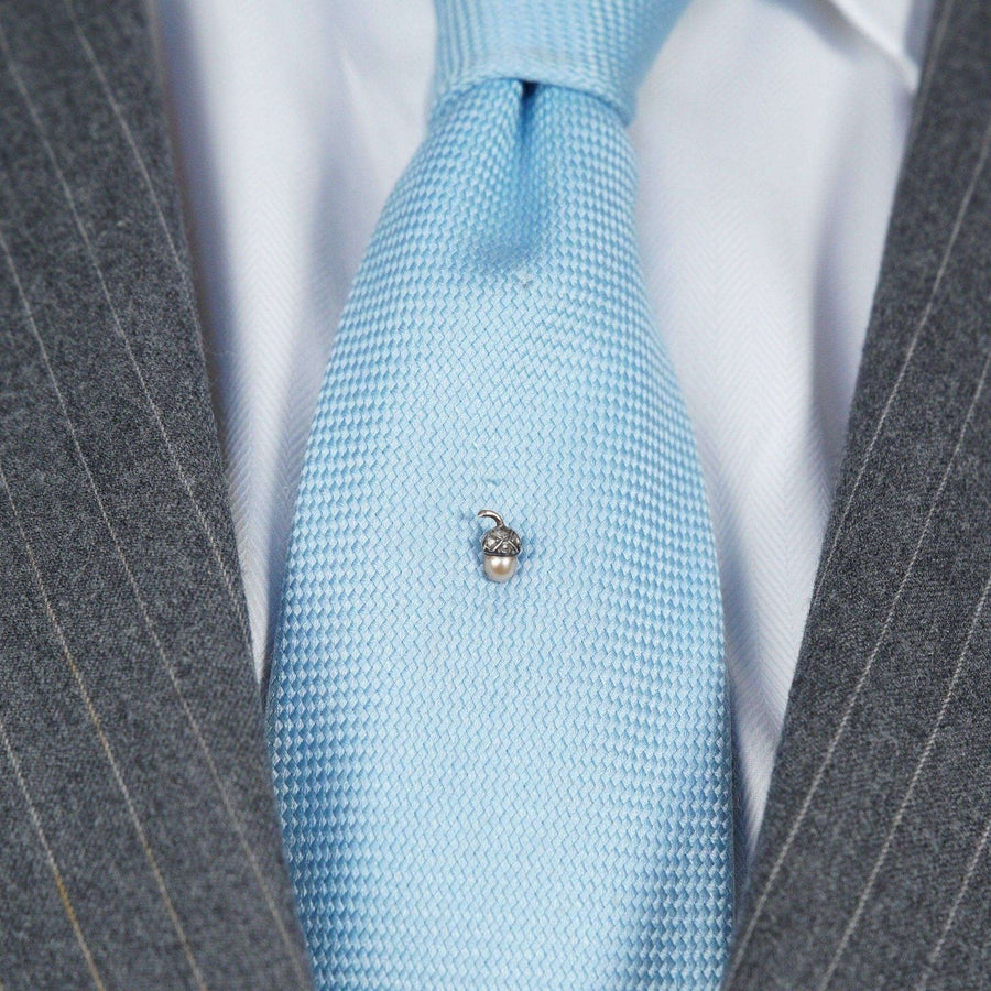 Edwardian 9ct gold and silver acorn tie pin on a light blue silk tie, symbolizing love and new beginnings.
