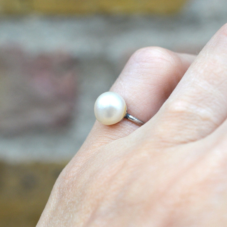 Edwardianischer Platinring mit einer glänzenden natürlichen Salzwasserperle, um 1910, elegant an einer Hand getragen.