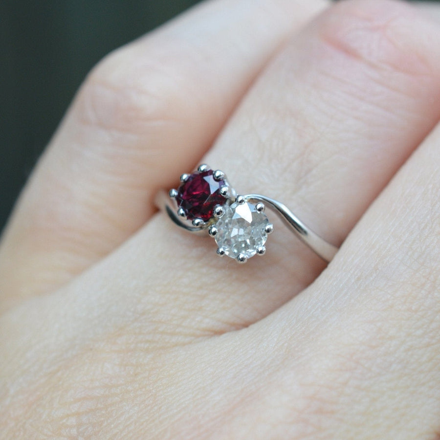 Edwardianischer Crossover-Ring mit einem Rubin und einem Diamanten im Altminenschliff als Symbol für Liebe und Verbundenheit.