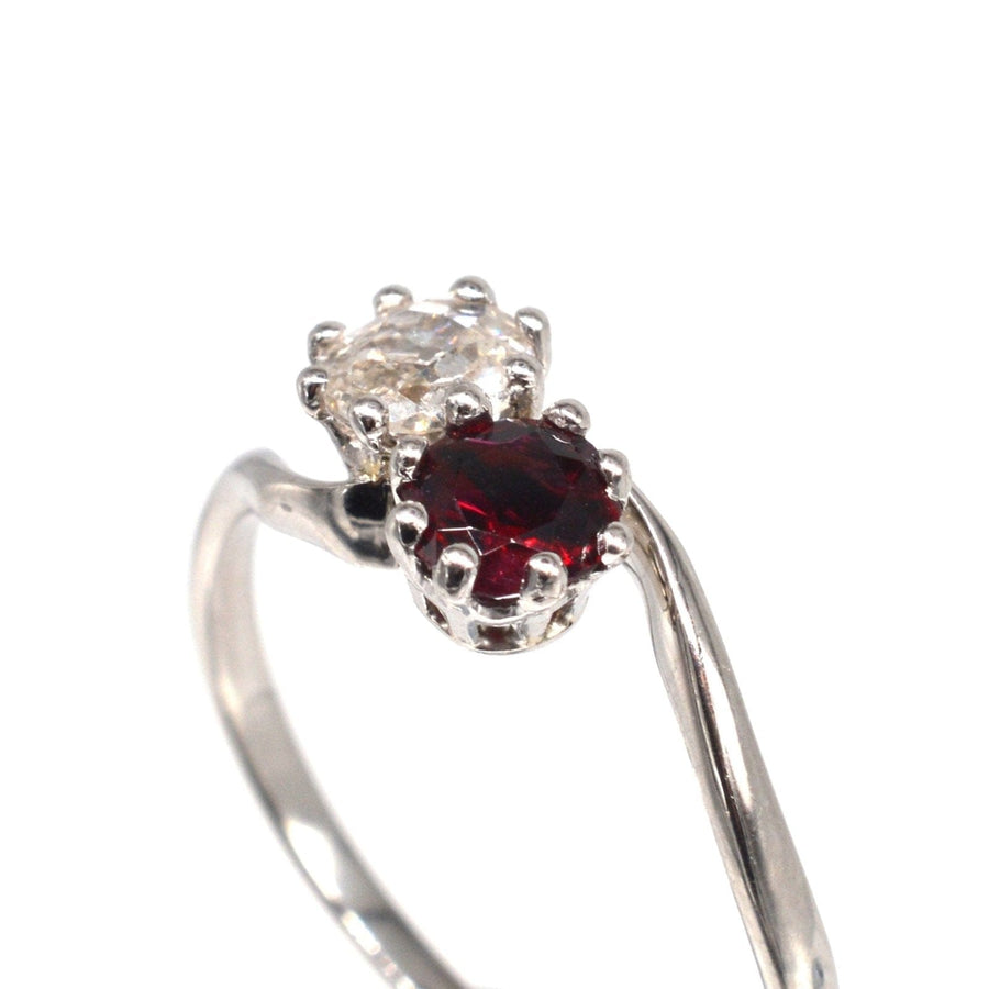 Edwardianischer Crossover-Ring mit einem Rubin und einem Diamanten im Altminenschliff, der Liebe und Romantik symbolisiert.