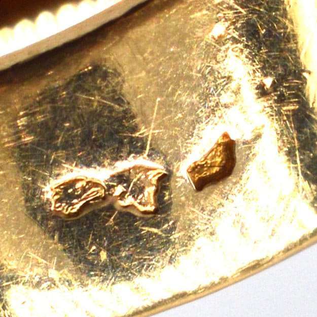 Nahaufnahme der Goldpunzierung auf einem alten Ring, die die Authentizität und die handwerklichen Details zeigt.
