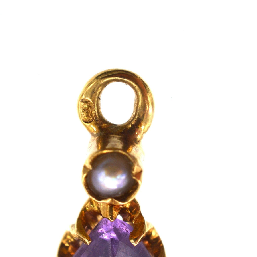 Nahaufnahme einer goldenen Ohrringfassung mit einem Amethyst und einer natürlichen Spaltperle, die ein kompliziertes Design aus dem 19. Jahrhundert zeigt.