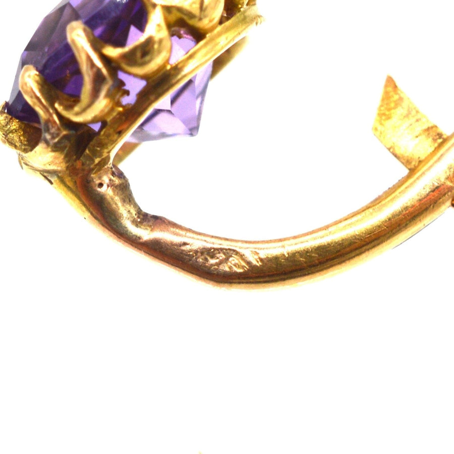 Nahaufnahme von goldenen Ohrringen aus dem 19. Jahrhundert mit Amethysten und Perlen, die die Handwerkskunst hervorheben.