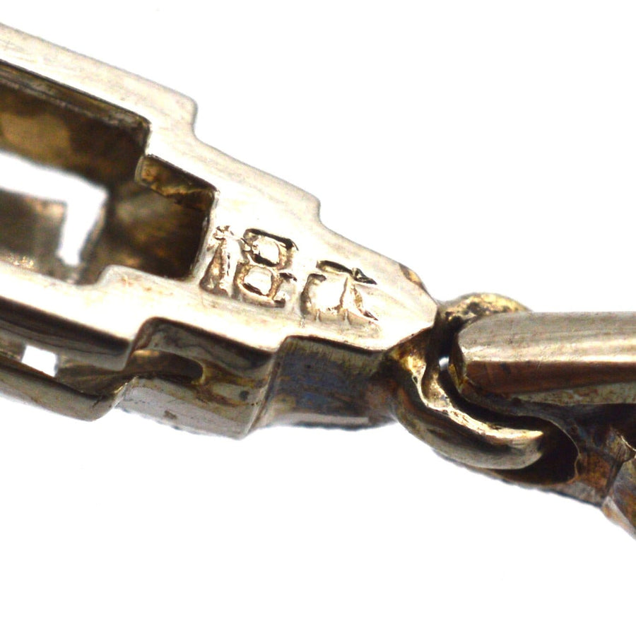Nahaufnahme eines Anhängers aus 18-karätigem Gold, der die Details und die Handwerkskunst der Marke zeigt.