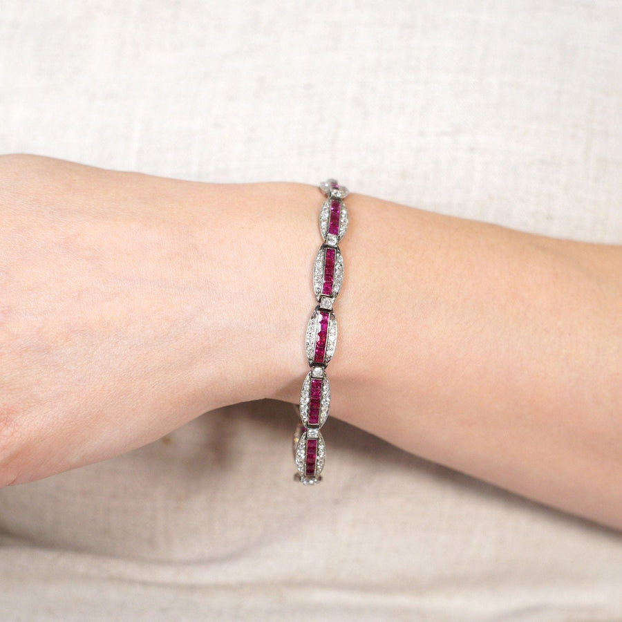 Antique 18ct gold and platinum bracelet featuring Burma rubies and diamonds, worn on a wrist against a neutral background.