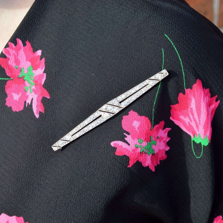 Große Art-Déco-Brosche aus Platin mit Diamanten an einer schwarzen Bluse mit Blumenmuster, die ihr elegantes Design und ihre funkelnden Diamanten zur Geltung bringt.
