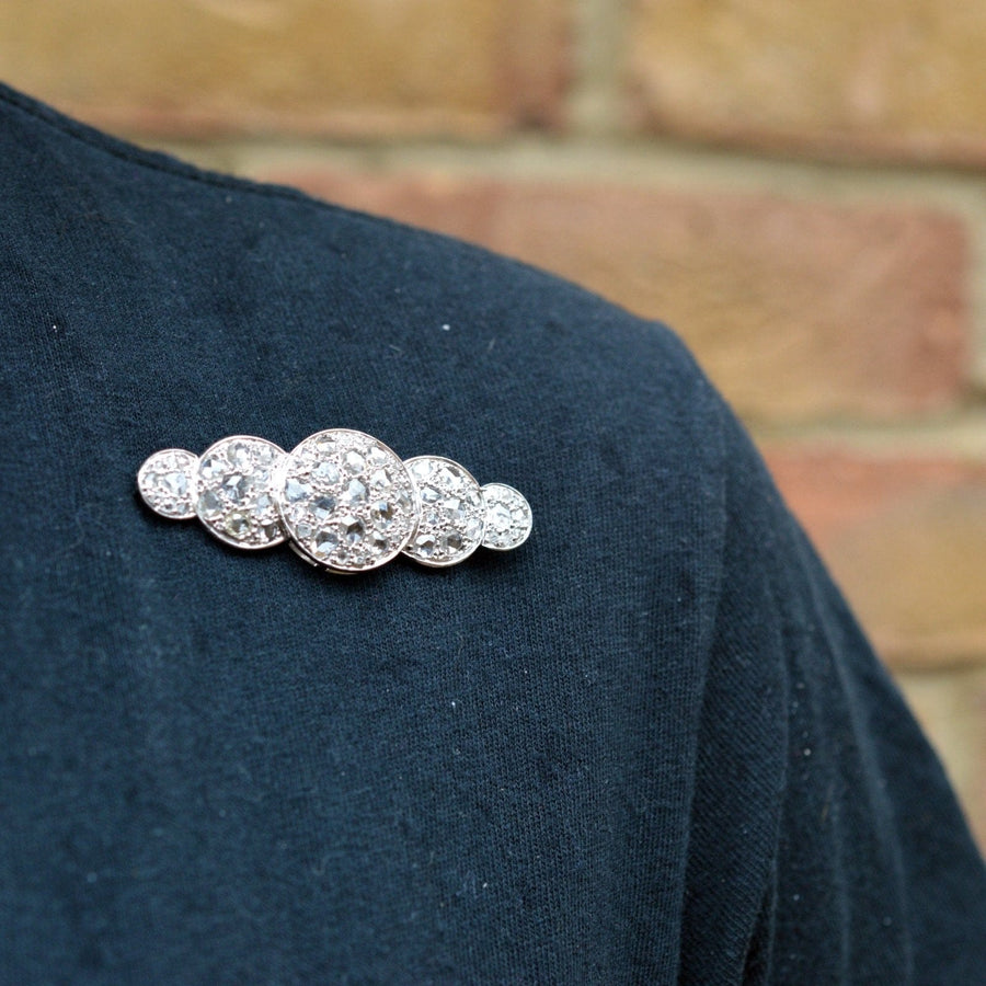 Große Art-Déco-Brosche mit einem Fünffach-Diamanten im Rosenschliff auf einem dunklen Hemd, die die Vintage-Eleganz der 1930er Jahre zeigt.