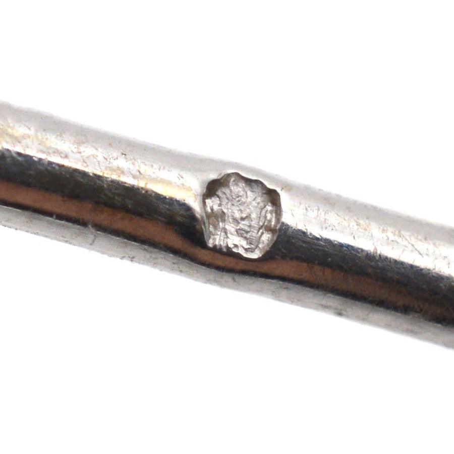 Nahaufnahme einer alten Silberbrosche aus den 1930er Jahren mit komplizierter Metallarbeit und Punzierung.