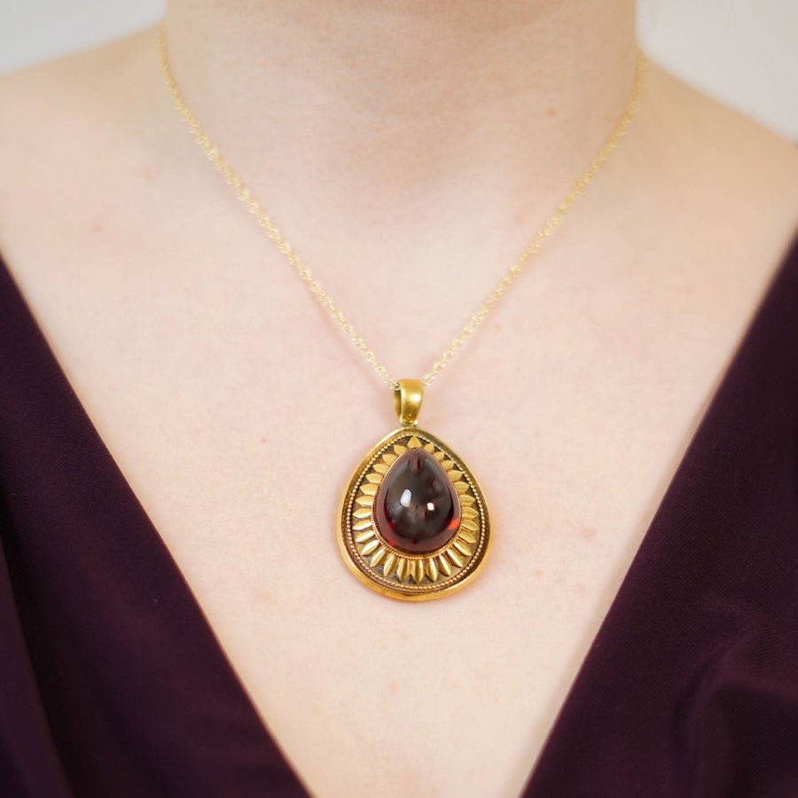 Großer viktorianischer Anhänger aus 15-karätigem Gold mit Cabochon-Granat, der an einem Modell getragen wird, mit komplizierten goldenen Blütenblättern und Perlen.