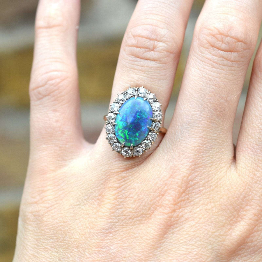 Large Victorian 18ct gold ring featuring a stunning black opal and diamond cluster, showcasing vibrant green and blue hues.