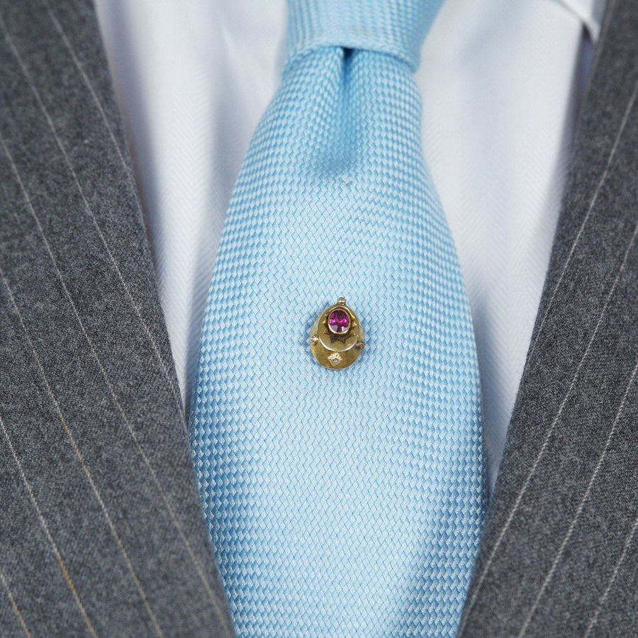 Spätviktorianische Krawattennadel aus 15-karätigem Gold mit roter Paste "Rubin" auf einer hellblauen Krawatte, die einen eleganten Vintage-Stil zeigt.