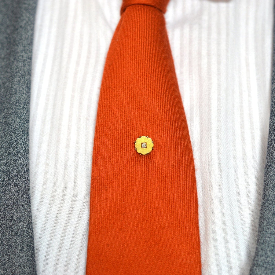 Elegante spätviktorianische Krawattennadel aus 15-karätigem Gold mit Blumen auf einer orangefarbenen Seidenkrawatte.