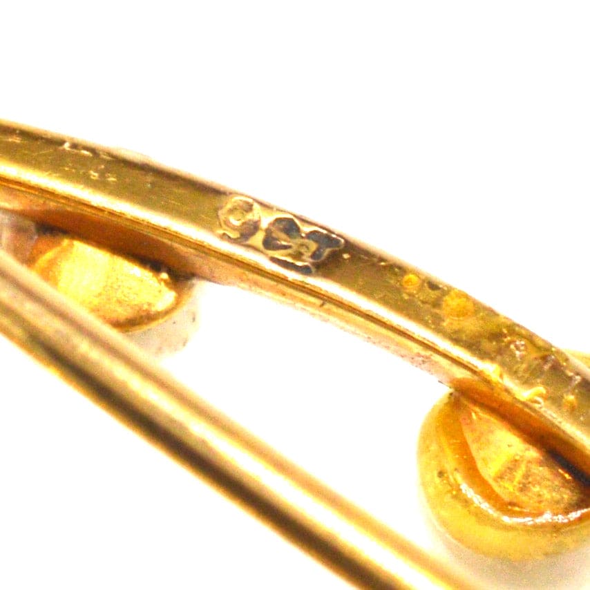 Nahaufnahme einer Marquise-Brosche aus 9-karätigem Gold, die das Markenzeichen und die raffinierte Handwerkskunst zeigt.