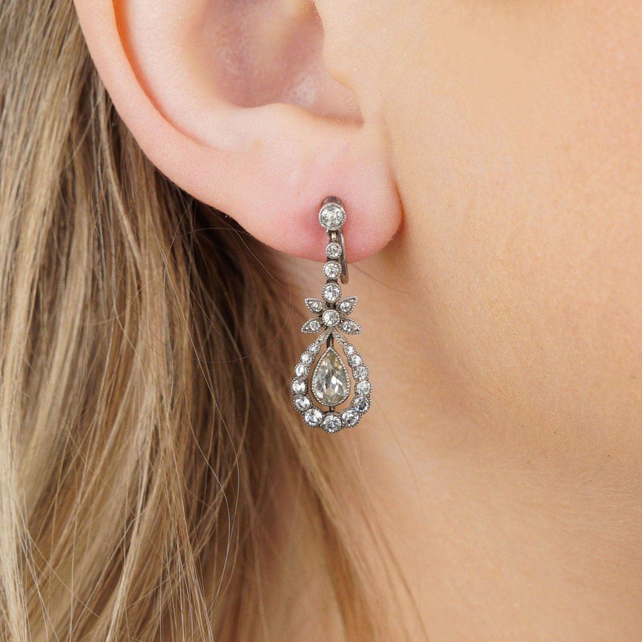 Elegant mid century silver and paste drop earrings displayed on a model's ear.