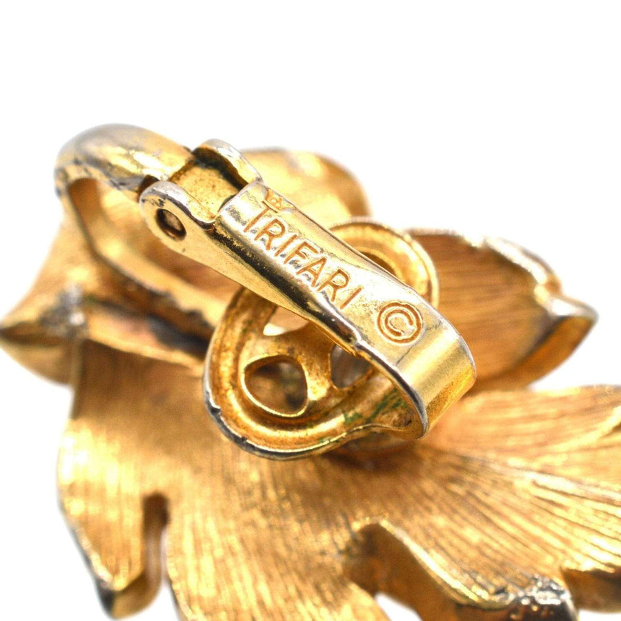 Nahaufnahme des vergoldeten Trifari-Metallverschlusses von Mid-Century-Blattohrringen, die barocke Handwerkskunst zeigen.