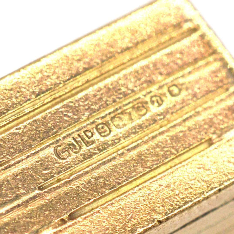 Nahaufnahme eines Charmes aus Gold und Emaille mit detaillierter Gravur von Georg Jensen Ltd.