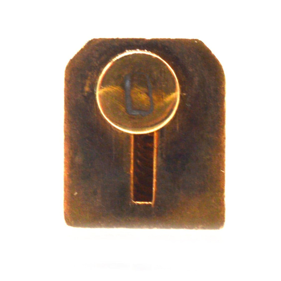 Miniatur-Messingschlüssel mit kreisförmigem Oberteil und rechteckigem Korpus, der eine aufwendige Handwerkskunst zeigt.
