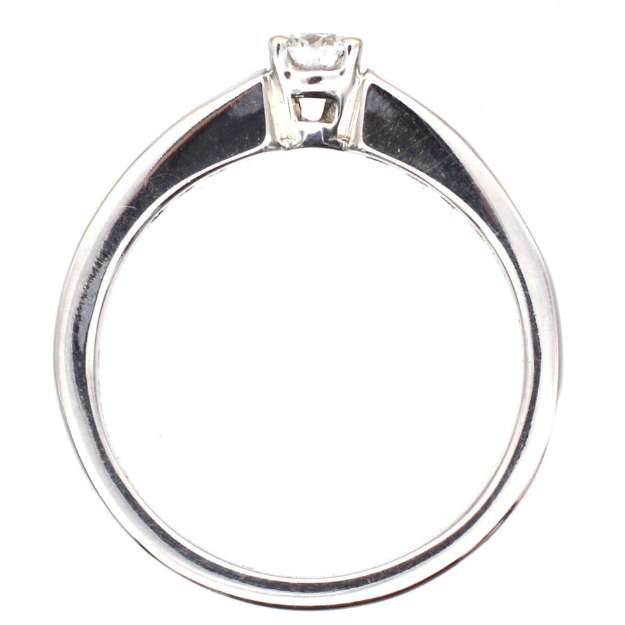 Moderner Solitärring aus 18 Karat Weißgold mit einem Diamanten im Brillantschliff in der Mitte und mit Diamanten in Kanalfassung an den Schultern.