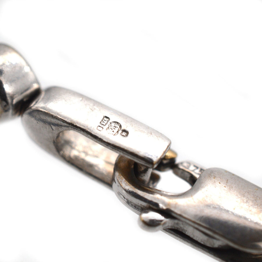 Nahaufnahme eines Verschlusses an einem Diamantarmband aus 9 Karat Weißgold, der die Qualitätspunze und die Metalldetails zeigt.