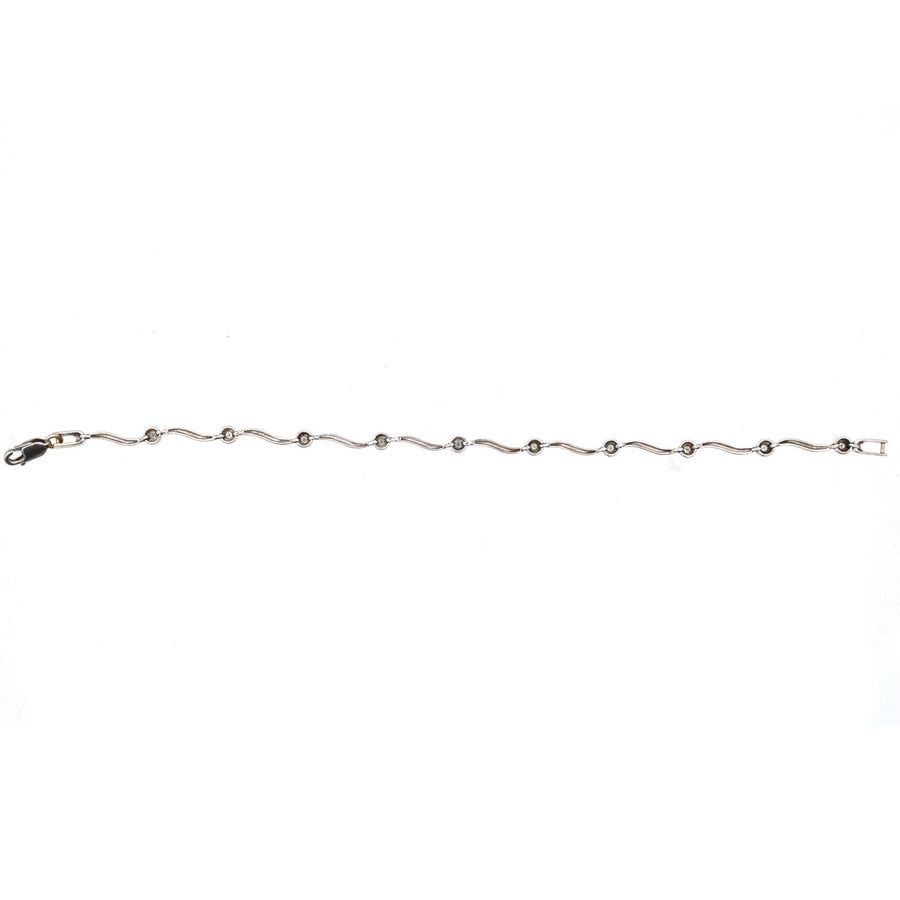 Modernes, gewelltes Diamantarmband aus 9 Karat Weißgold mit 10 funkelnden Diamanten, perfekt für elegante Geschenke.