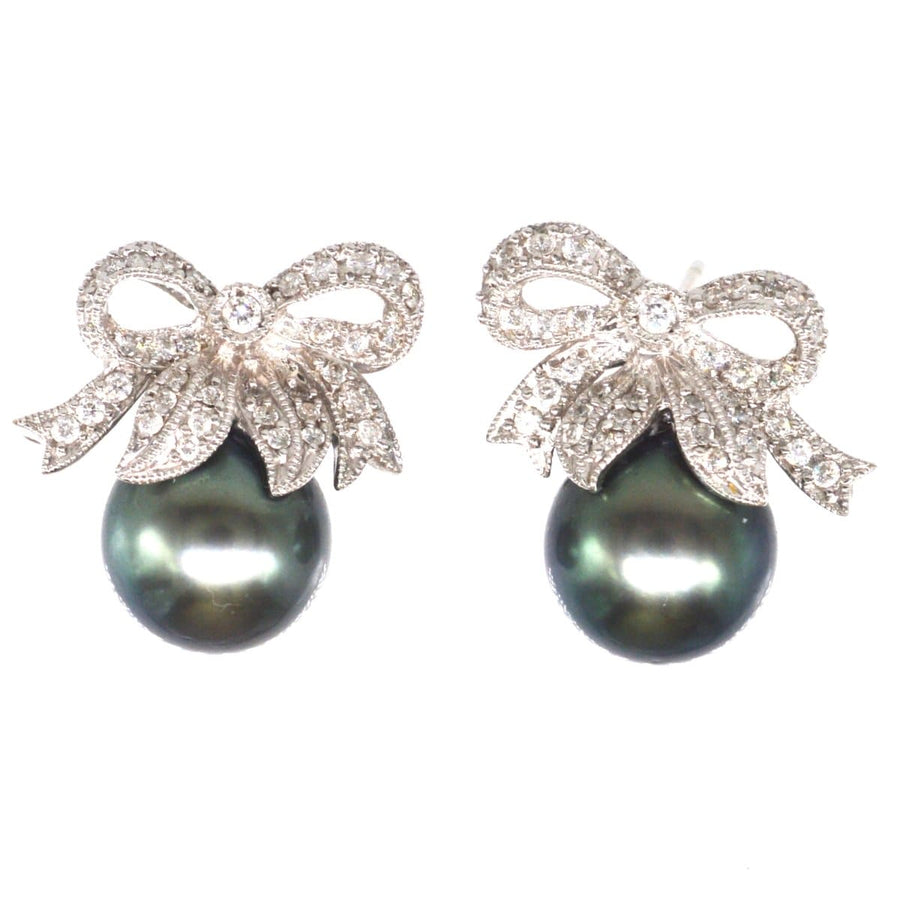 Moderne Ohrstecker mit Diamantschleife und schwarzer Tahiti-Perle, elegant und schick für zeitlosen Stil.