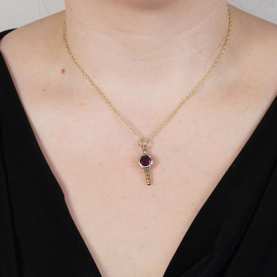 Eleganter Schlüsselanhänger mit Goldgehäuse und Amethystpaste, gestylt im Regency-Stil an einem Modell.
