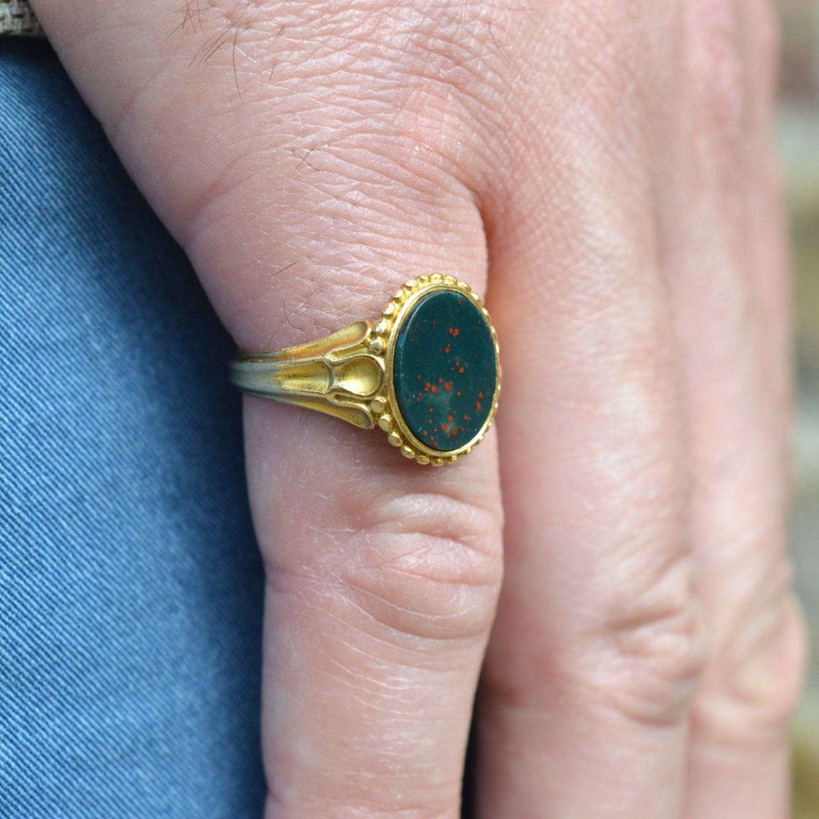 Viktorianischer Siegelring aus 18-karätigem Gold mit Blutstein, der an einer Hand getragen wird und exquisite Details und Handwerkskunst zeigt.