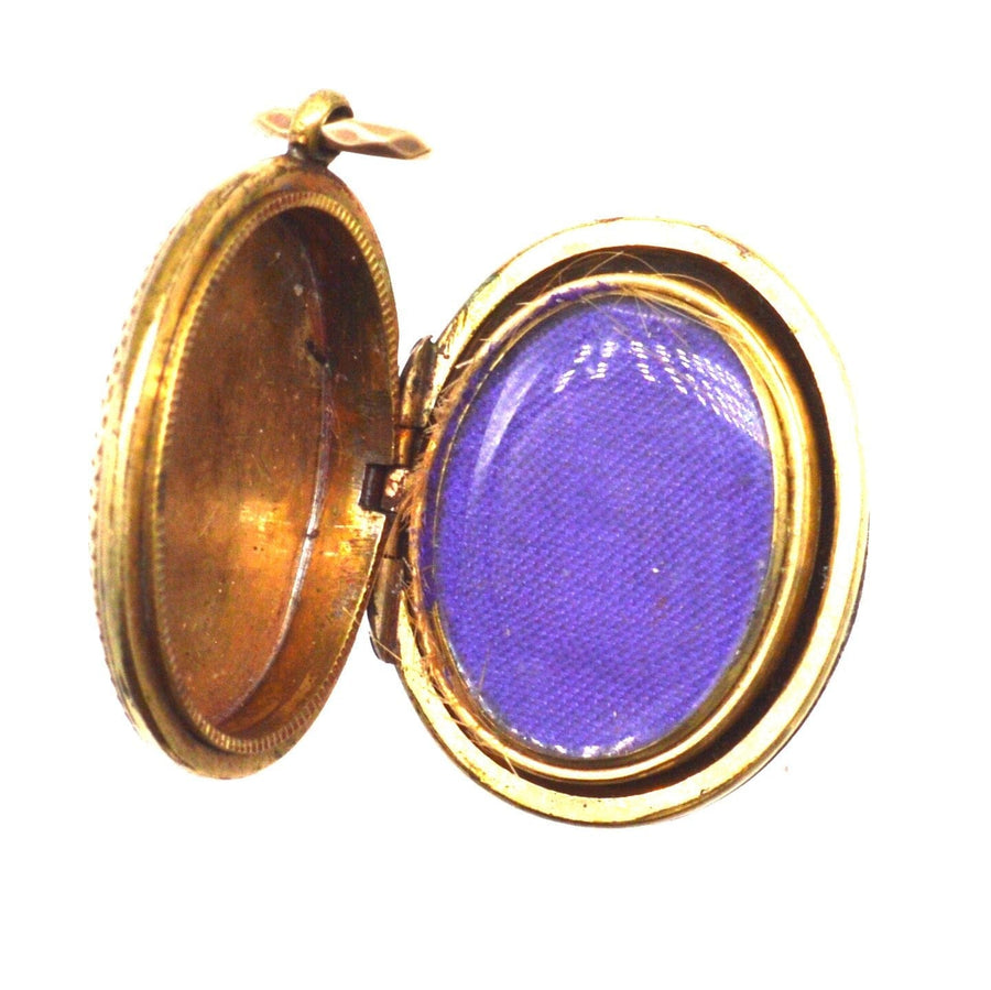 Offenes viktorianisches Medaillon aus 9-karätigem Gold mit Blumenmotiv, das sein Innenfach mit lila Stoff präsentiert.