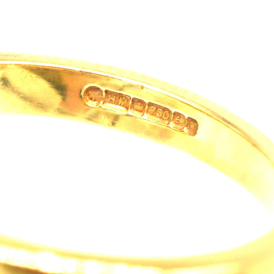 Nahaufnahme der Punzierung eines Rings aus 18 Karat Gold, die auf Qualität und Echtheit hinweist.