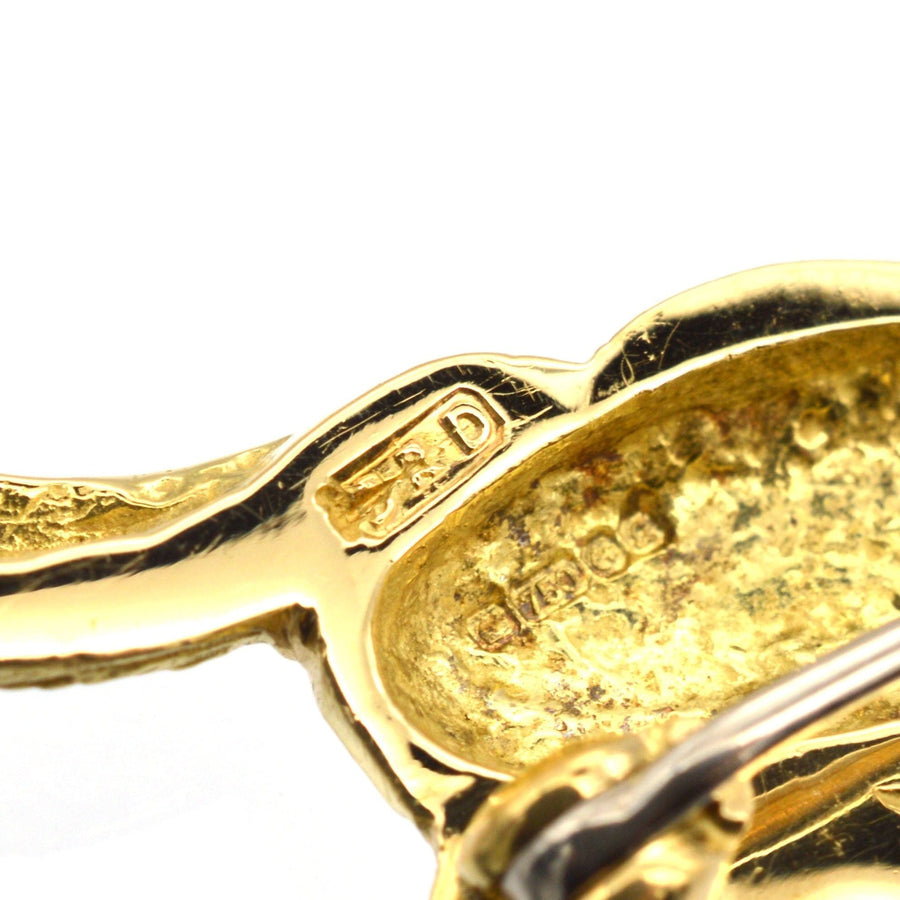Nahaufnahme einer Kaninchenbrosche aus 18 Karat Gold mit handwerklichen Details und Punzierung.